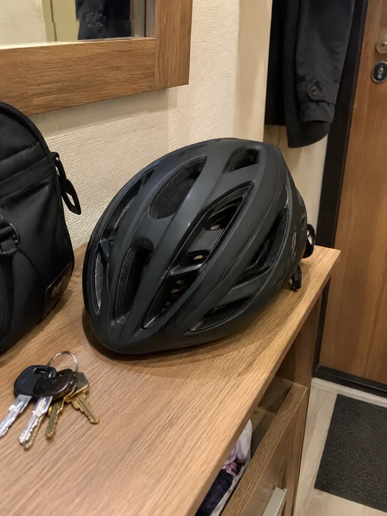Чёрный велошлем на полке в прихожей рядом с ключами
